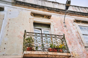 Europa, Portugal, Algarve, Litoral, Sotavento, Distrikt Faro, Olhao, Balkon an einer verwitterten Hausfassade, Metallgeländer mit Ornamenten Europa, Portugal, Algarve, Litoral, Sotavento, Distrikt Faro, Olhao, Balkon an einer verwitterten Hausfassade, Metallgeländer mit Ornamenten
